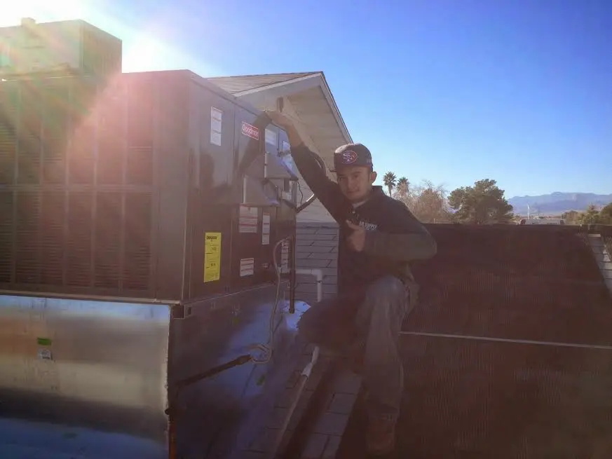 HVAC technician performing AC Tune-Up on a rooftop unit in Lake Los Angeles
